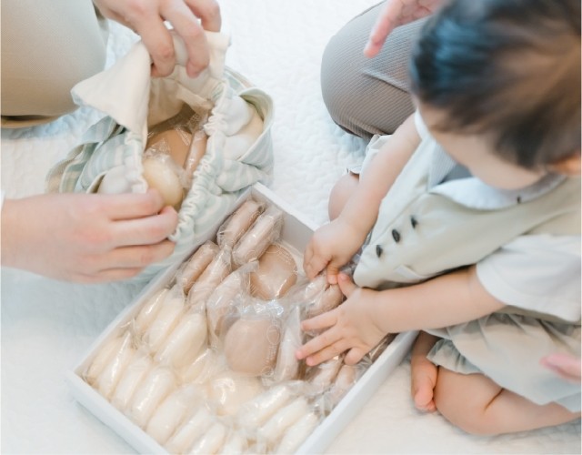 1歳のお祝いで一升餅を前に笑顔を見せる赤ちゃん