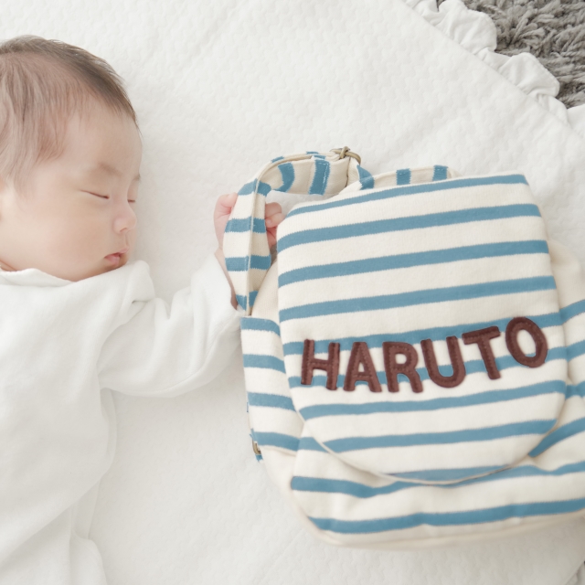 名前入りベビーリュックと添い寝する赤ちゃん｜出産祝いに人気のオリジナルギフト