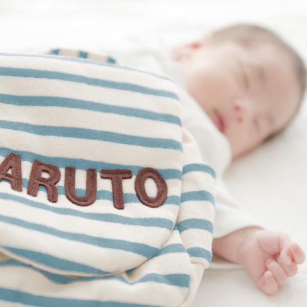 名前入りベビーリュックと添い寝する赤ちゃん｜出産祝いに人気のオリジナルギフト
